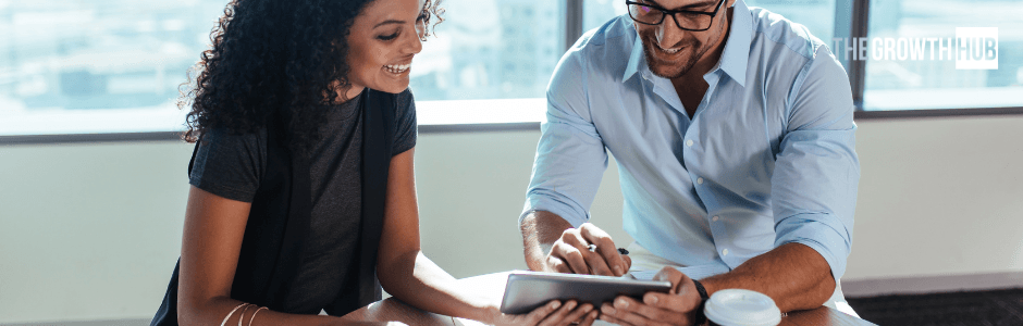 Two people looking at data on a tablet
