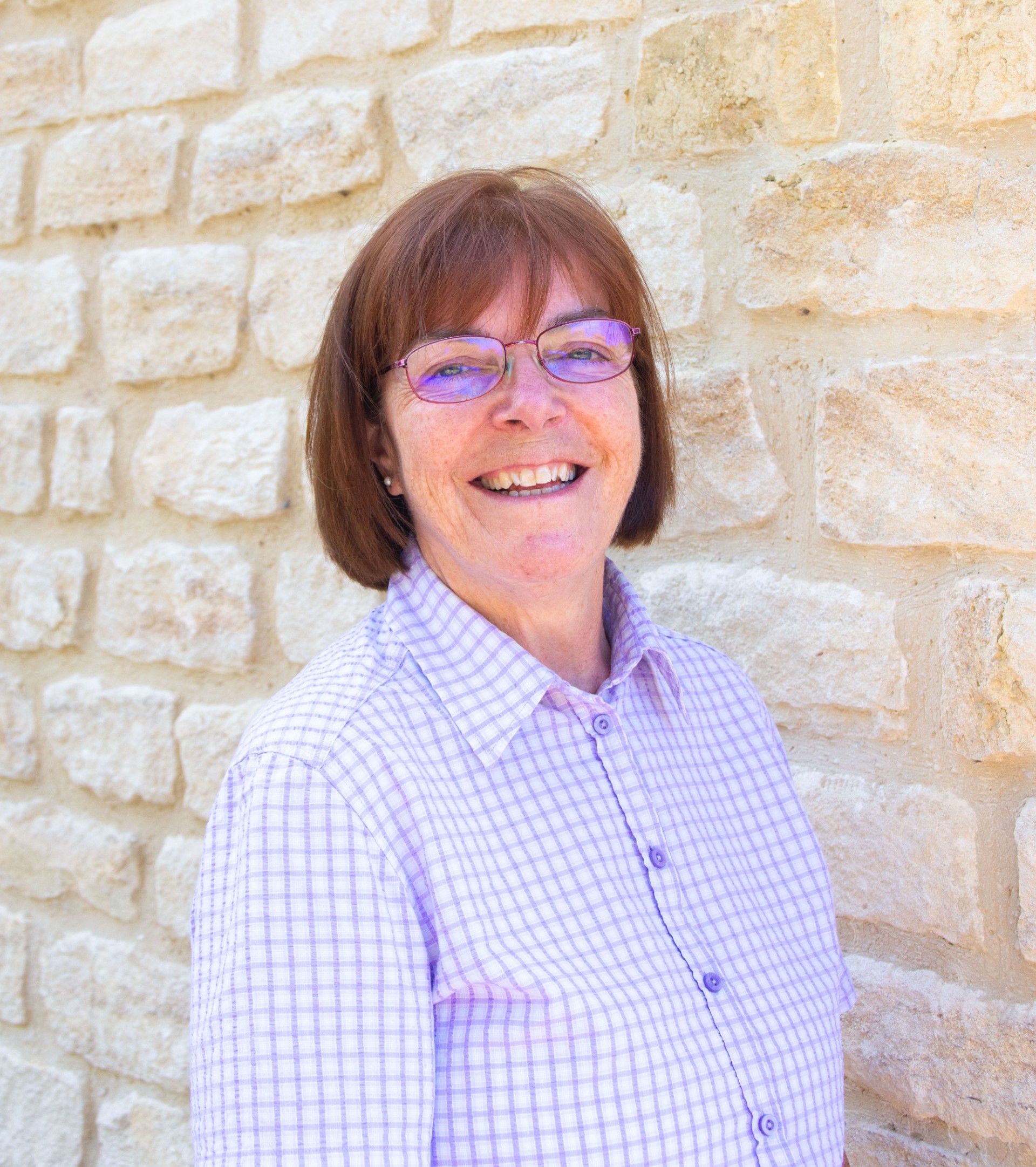 Image of lady standing next to Cotswold stone wall